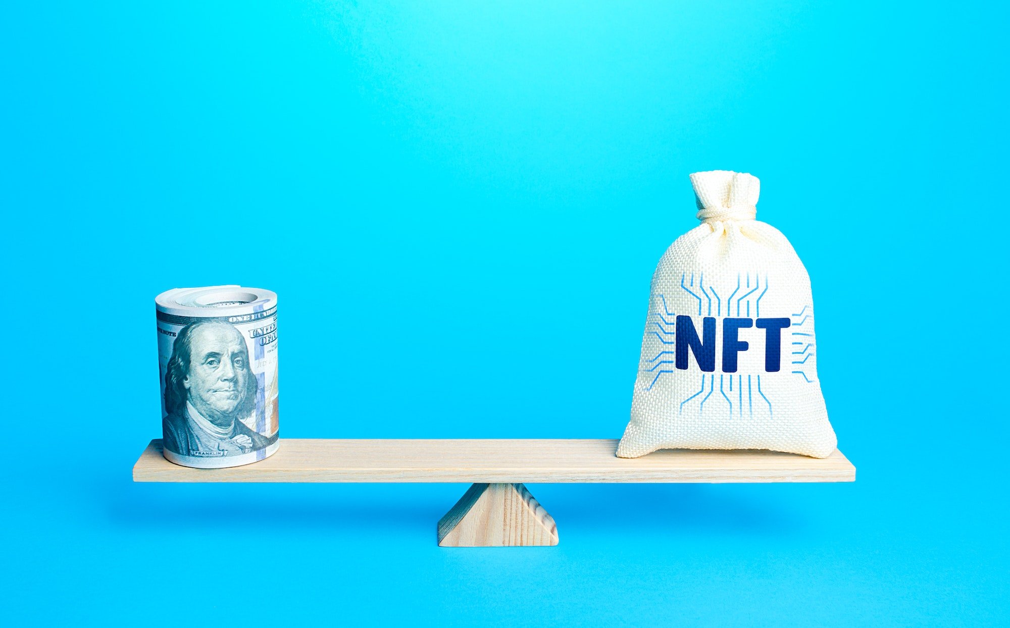 Bag with NFT non-fungible token and a bundle of dollars on scales.